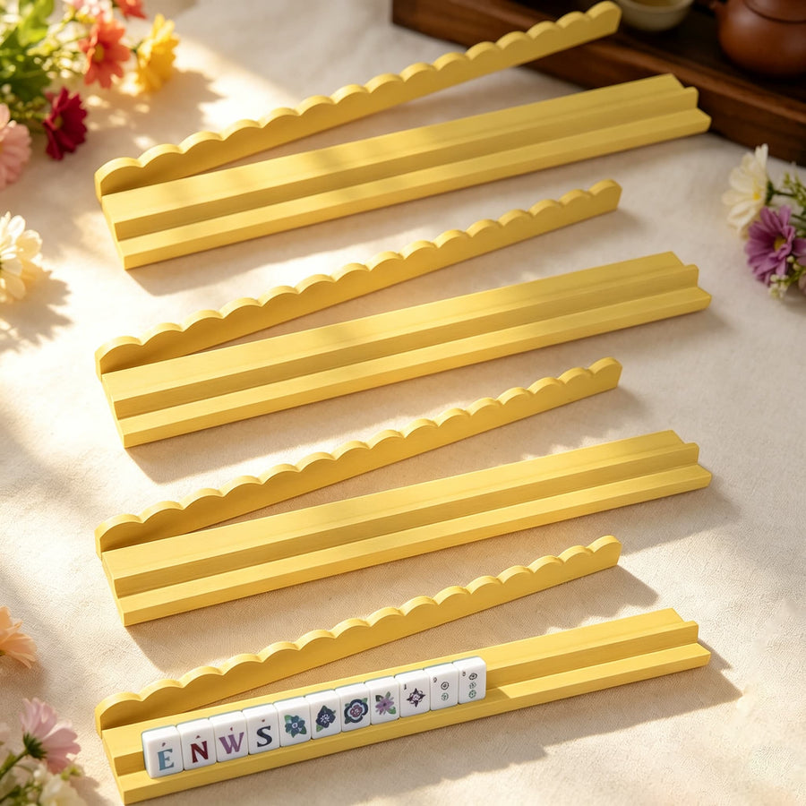 Yellow wooden Mahjong racks laid parallel with a row of letter tiles in the front rack.