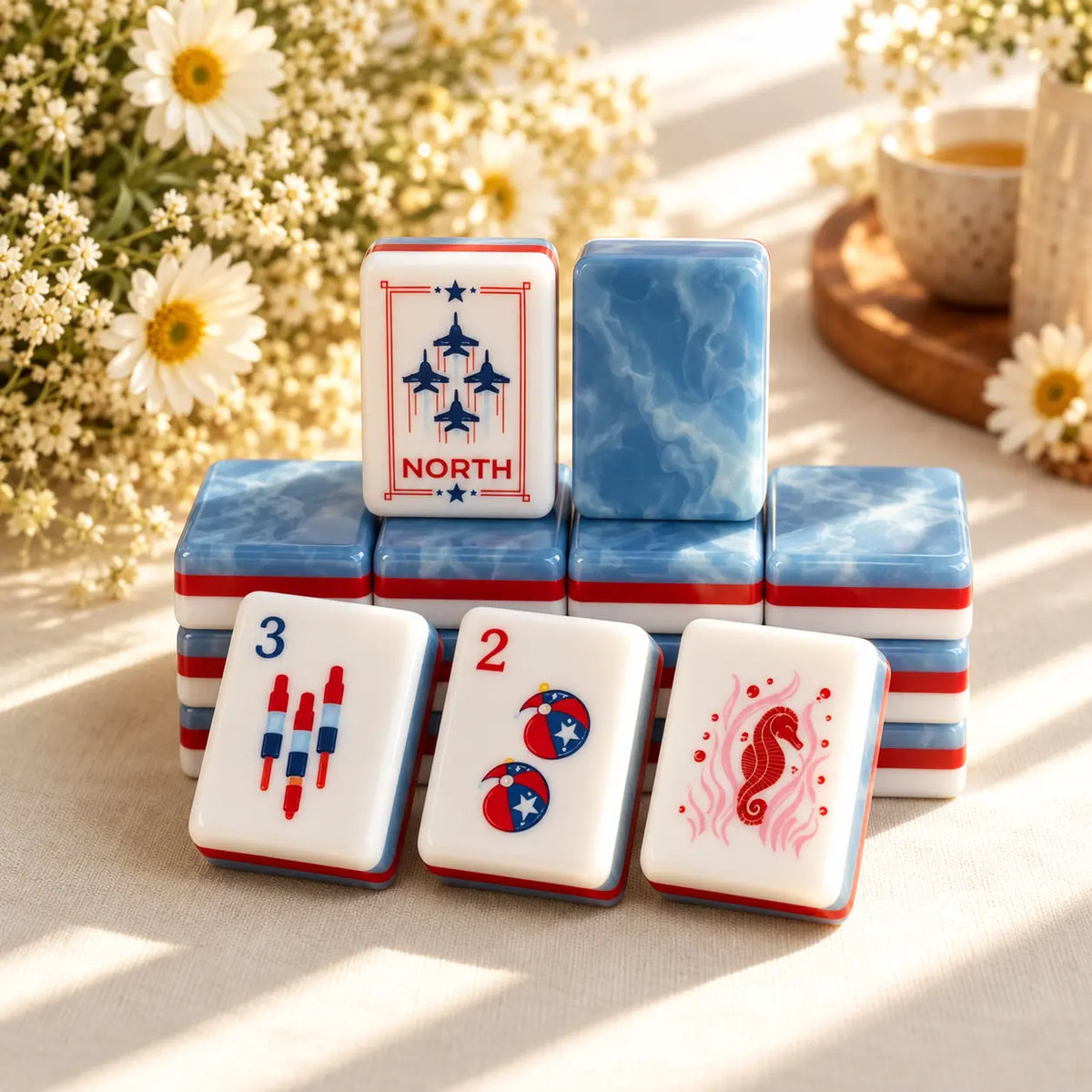 American Mahjong tiles with blue marbled backs and red-white striped sides, showing North and red-and-blue themed faces.