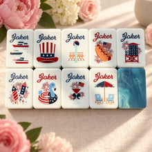 Nine patriotic Mahjong Joker tiles with fireworks, flags, a hot dog and beach imagery beside a blue marbled tile back.