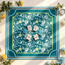 Teal Mahjong mat with white botanical vines and yellow flowers inside an Art Deco border, with wind tiles at the center.